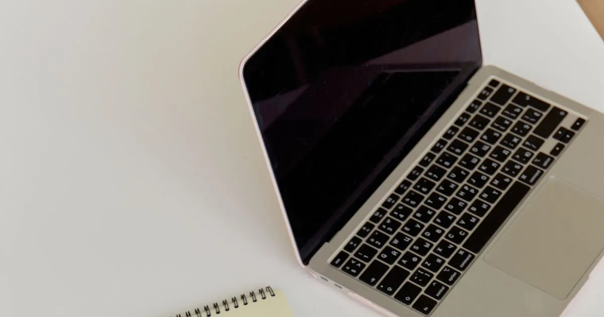 A brainstorming notepad beside a laptop